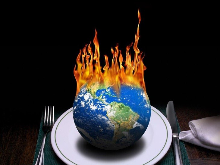 Burning Earth on a dinner plate flanked by silverware.