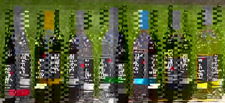 (Credit: Love Cork Screw) Wine bottles lined up on stone wall against grassy background