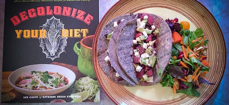 (Credit: Esperanza Center) Copy of book sits on slate grey background next to a brown plate of tacos