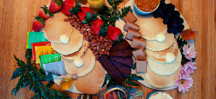 Pancake board garnished with dried leaves. berries and cookies