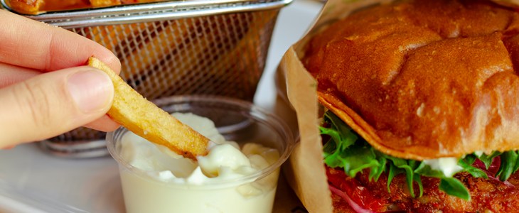 Veggie Burgers in a paper wrapper next to french fries