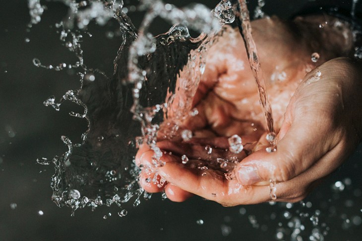 Close up of hands cupping flowing water