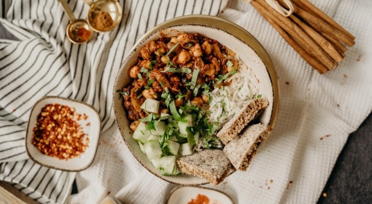 Bowl of spiced chickpeas with white rice and bread