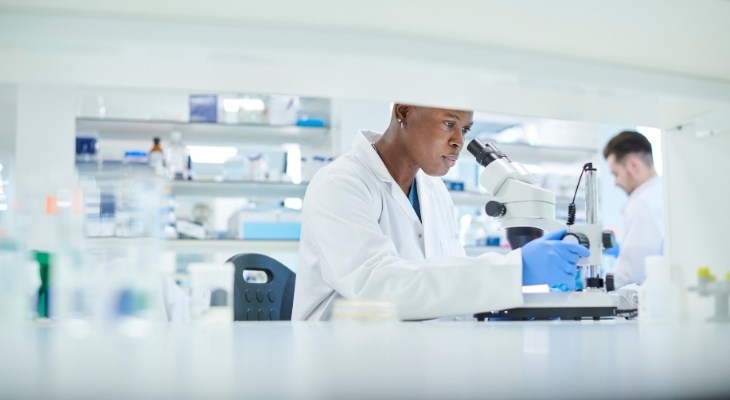 Scientist looking into a microscope in a lab