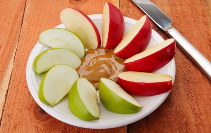 Apples and peanut butter on a plate