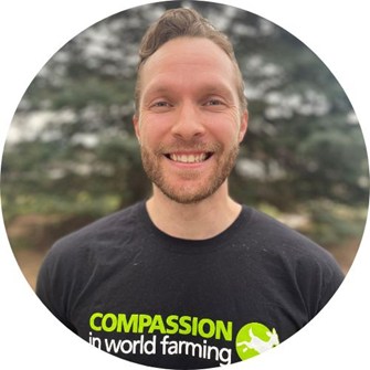 Ryan smiling at the camera wearing a black Compassion in World Farming t-shirt
