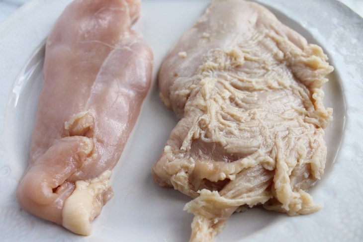 A higher welfare piece of raw chicken next to spaghetti meat